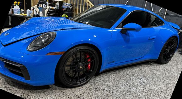 A blue porsche 911 gt3 is parked in a garage.