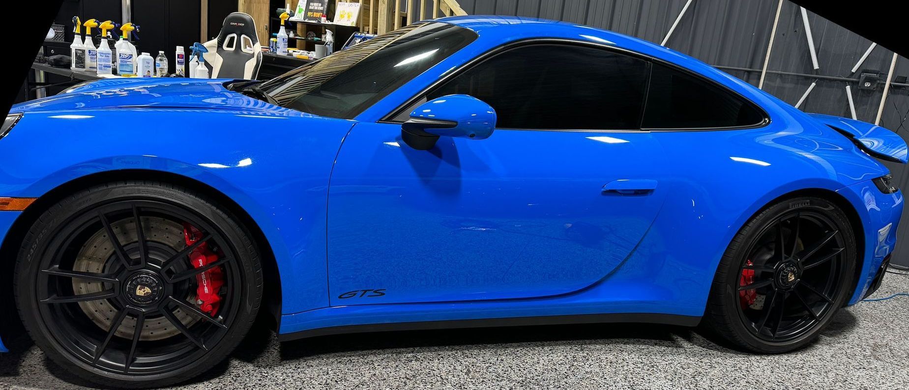 A blue porsche 911 gt3 is parked in a garage.