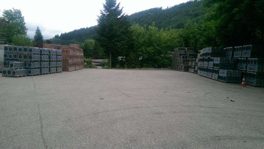 Ein großer leerer Parkplatz mit vielen übereinander gestapelten Ziegelsteinen.