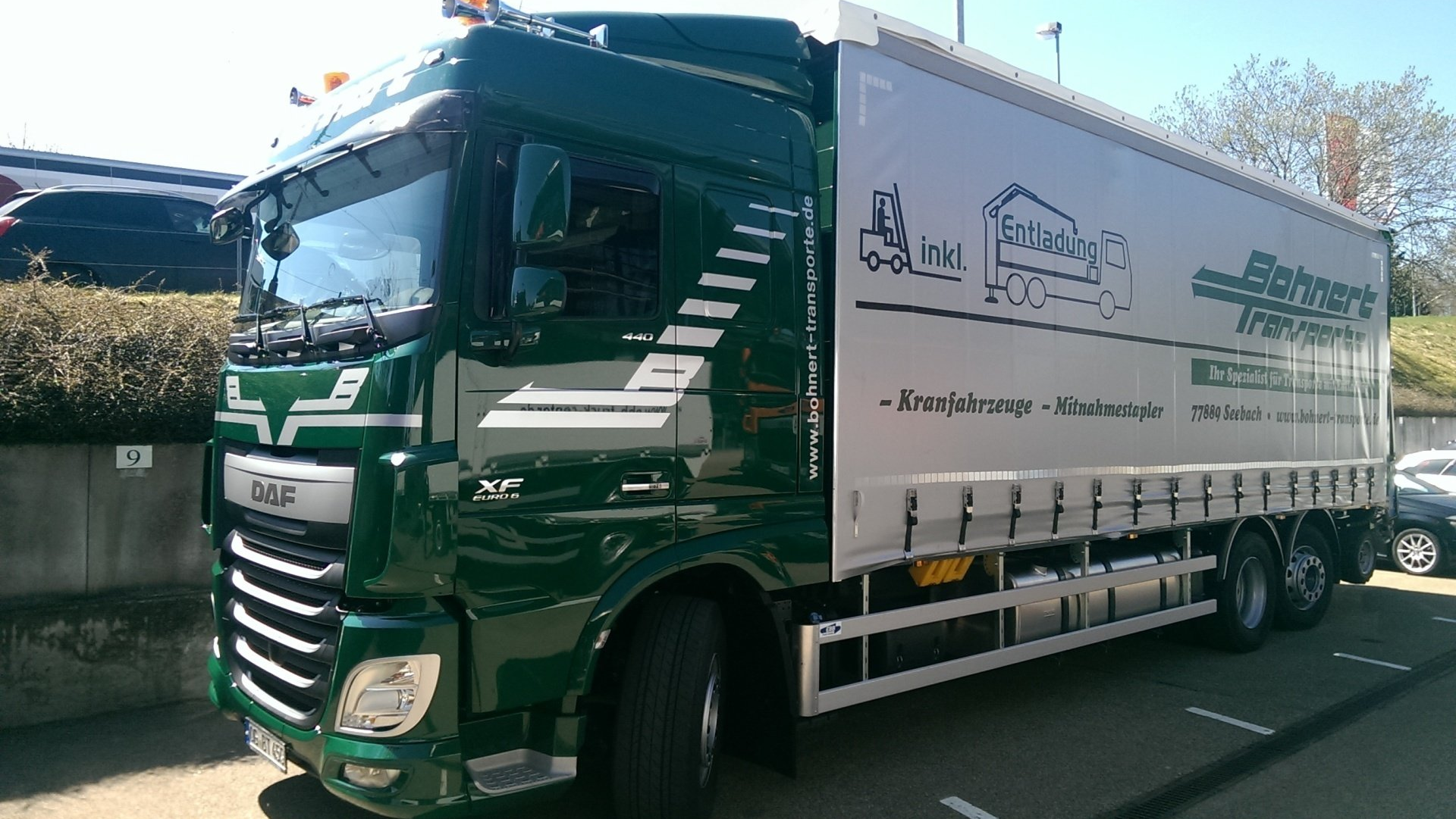 Ein grün-weißer Lastwagen steht am Straßenrand.