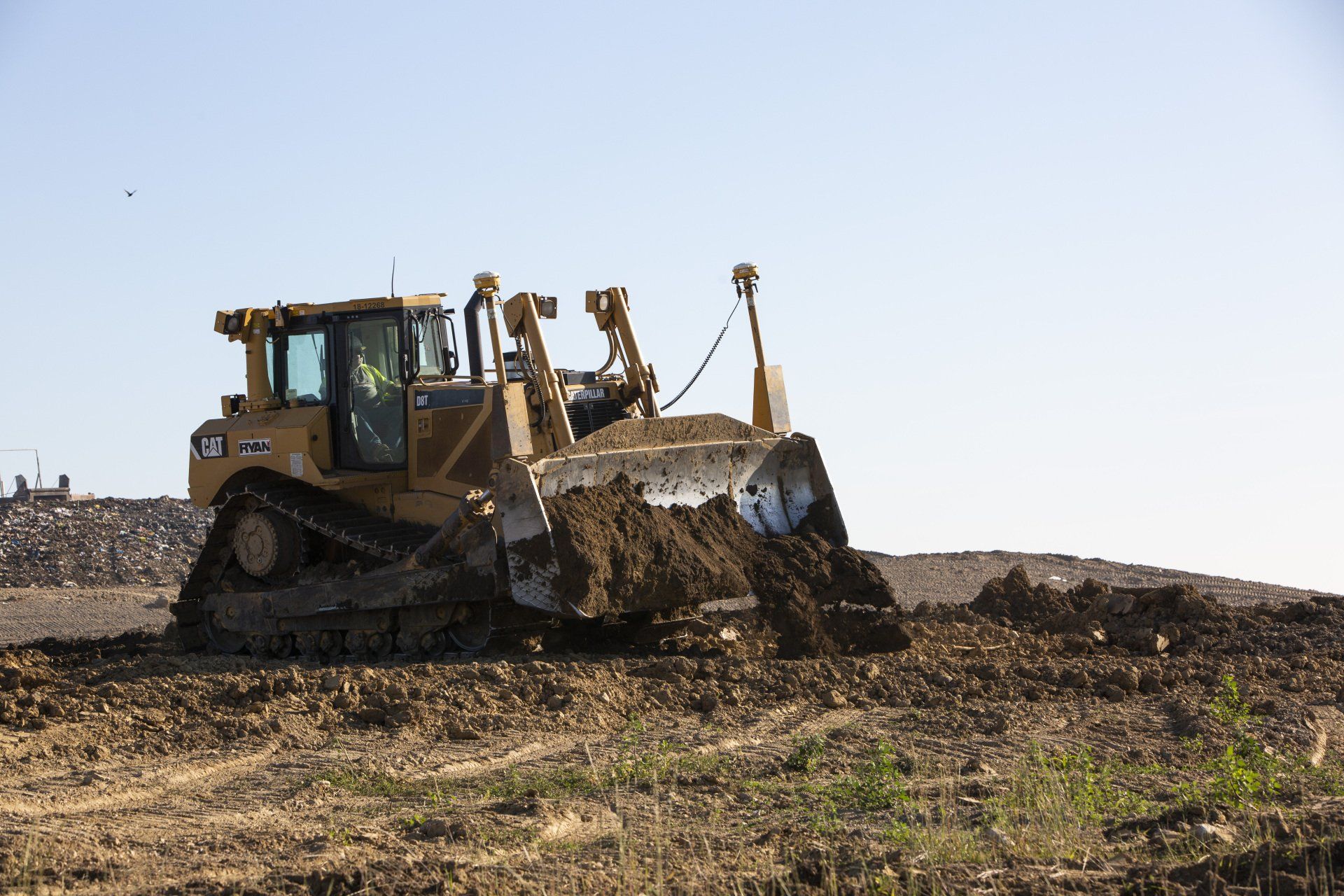 A bulldozer is moving dirt in a field.