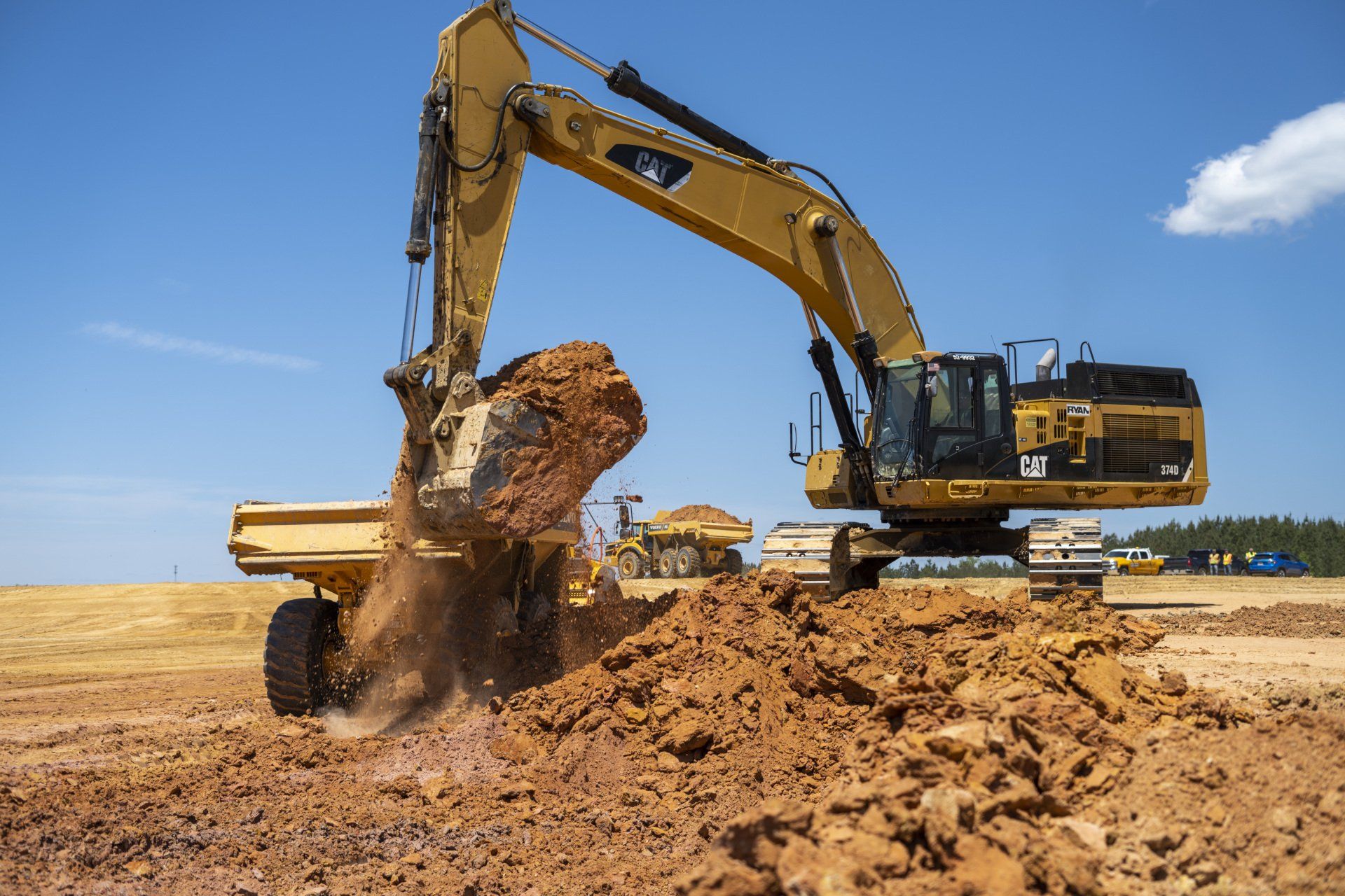 A large excavator is digging a hole in a dirt field.