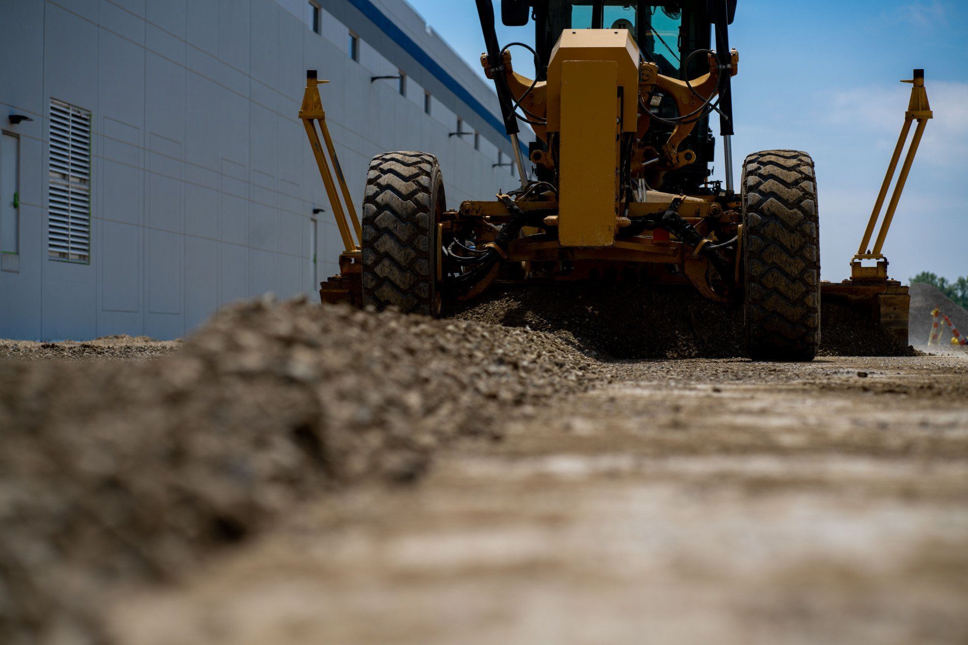 A bulldozer is moving dirt on a construction site in front of a building.