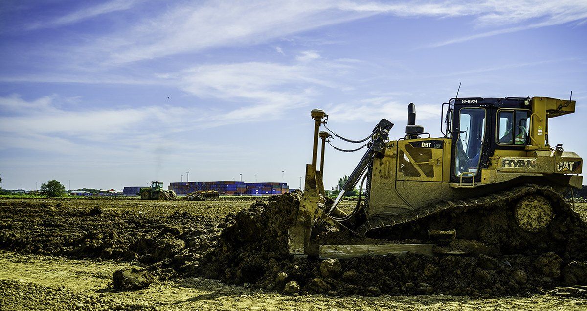 A bulldozer is moving dirt in a field.