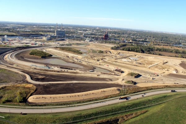 An aerial view of a construction site with a city in the background.