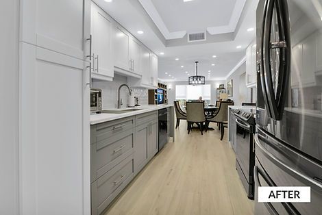 Modern kitchen with white and gray cabinets, stainless steel appliances, and wood flooring. Dining area visible in background.