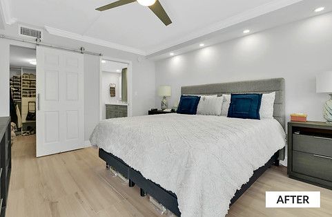 Bedroom with king-sized bed, white walls, light wood floors, and a walk-in closet.