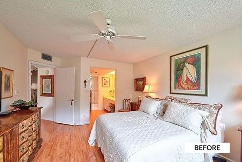 Bedroom with a bed, dresser, art, and doorway to a bathroom; neutral colors with a ceiling fan.