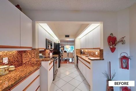 Kitchen with white cabinets, granite countertops, and a view into a dining area. 