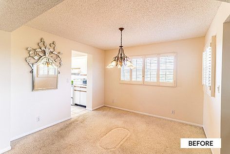 Dining room with tan carpet, white walls, ornate mirror, chandelier, and a window with white shutters. 