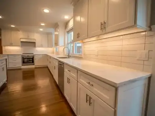 Bright, white kitchen with wood floor, white cabinets, and stainless steel appliances.