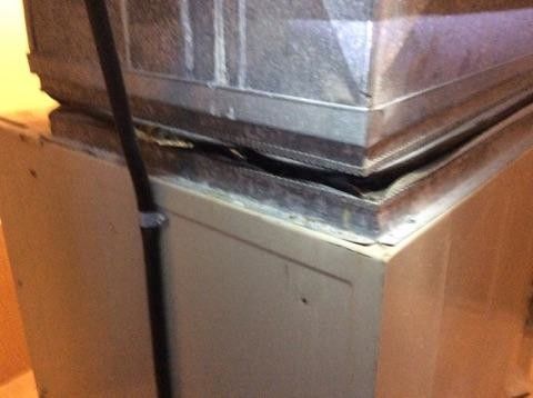 A broken air conditioner is sitting on top of a wooden box.