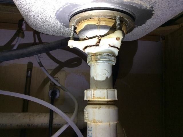 A sink with a broken pipe underneath it