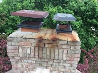 A brick chimney with two chimney caps on top of it.