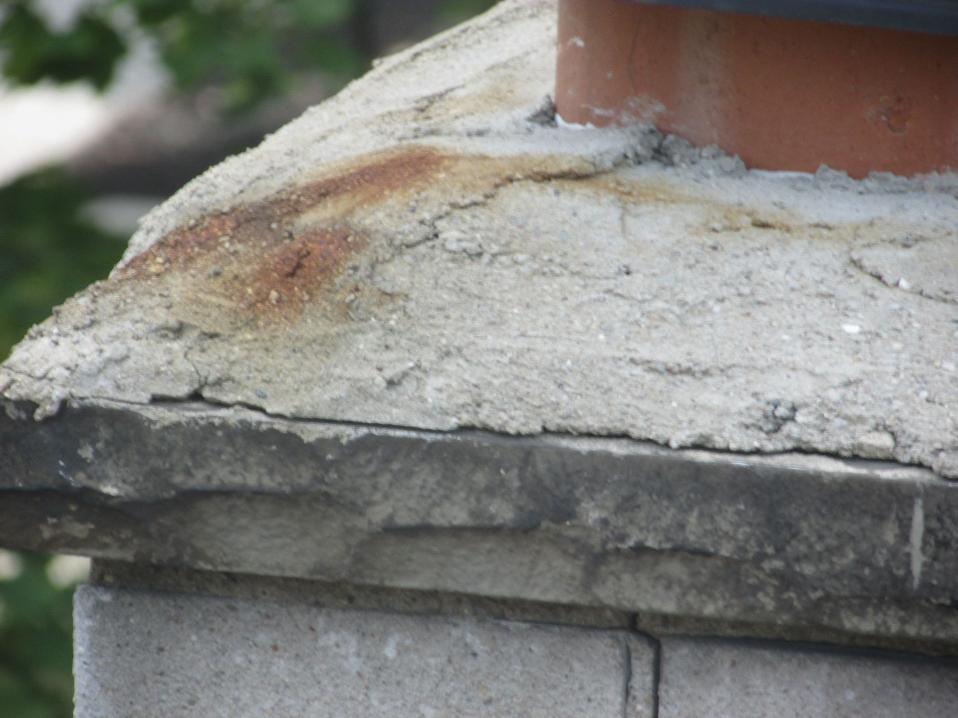 A chimney is sitting on top of a concrete pillar