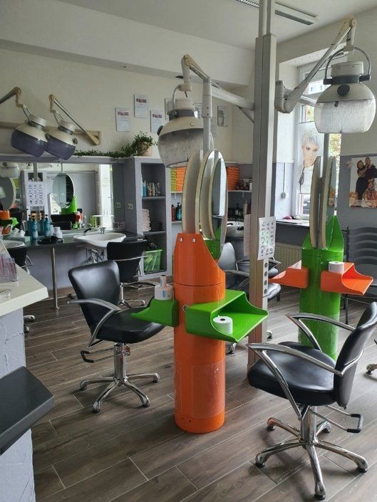 Ein Friseursalon mit vielen Stühlen und Lampen