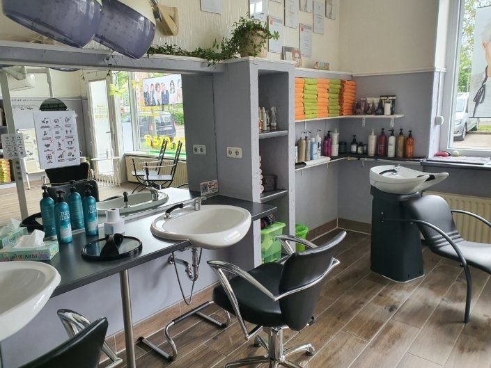 Ein Friseursalon mit vielen Stühlen und Waschbecken