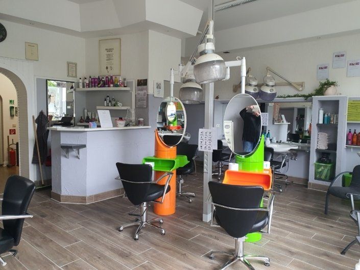 Ein Friseursalon mit vielen Stühlen und Spiegeln