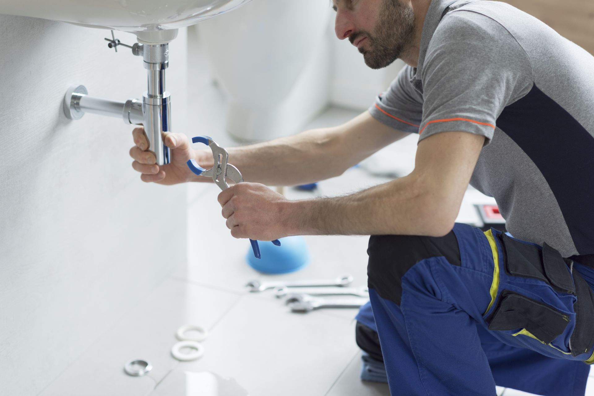 Professional plumber checking a sink drain.