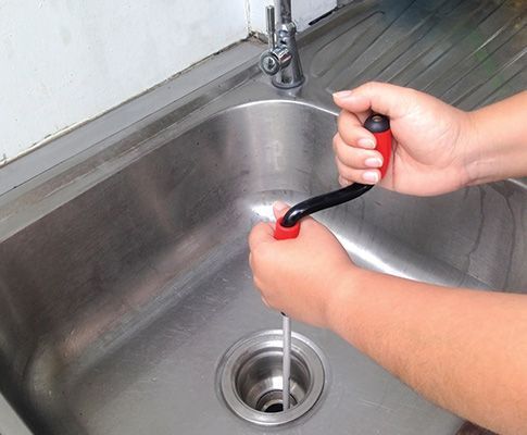 A Person Using A Clog Pipe Cleaner — Santa Maria, CA — Zeek's Plumbing