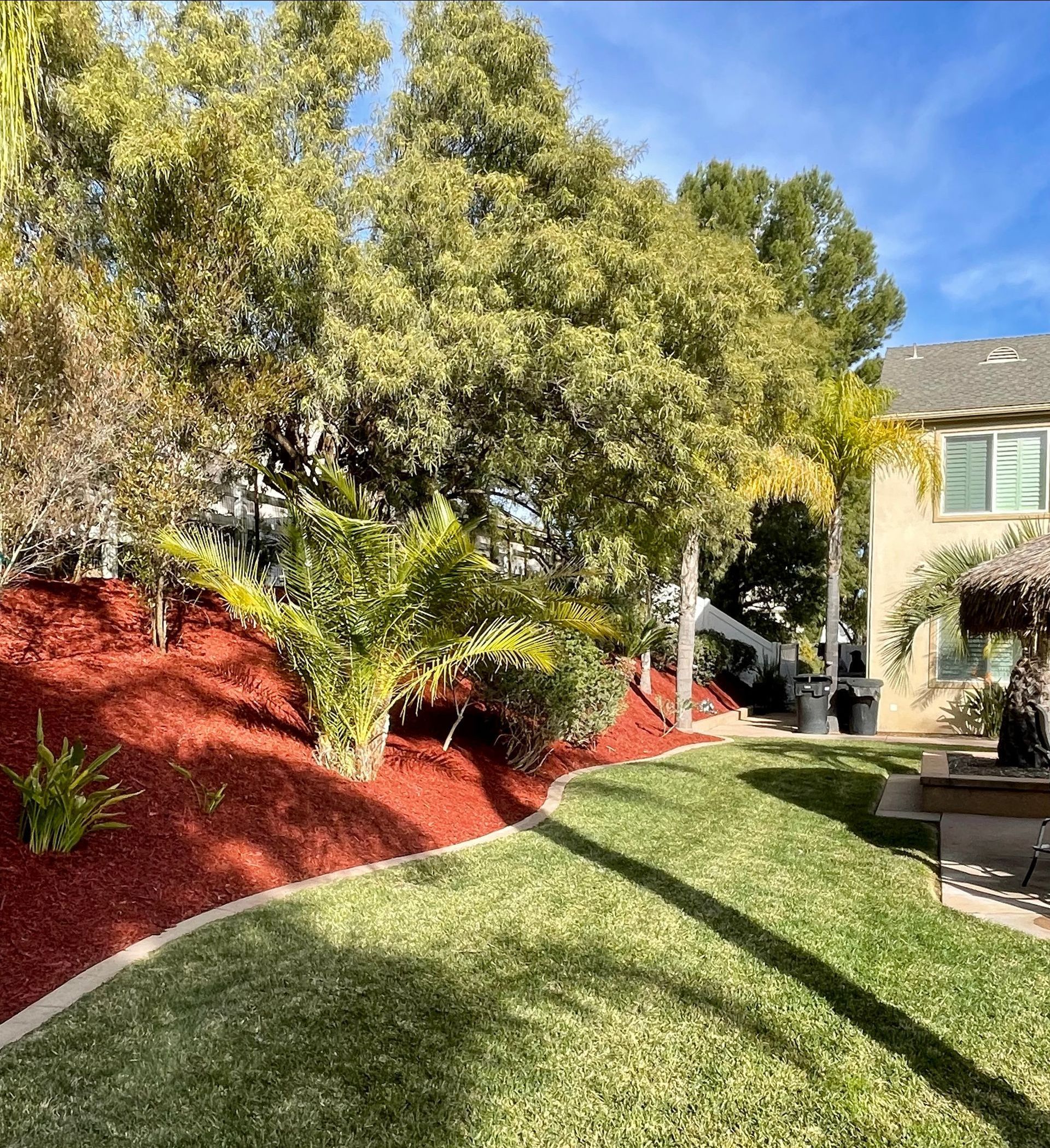 there is a house in the background and a lush green lawn in the foreground .