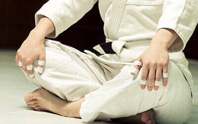 Girl Wearing Tae Kwon Do Attire Kneads Before Training — Tae Kwon Do in Huntington, WV