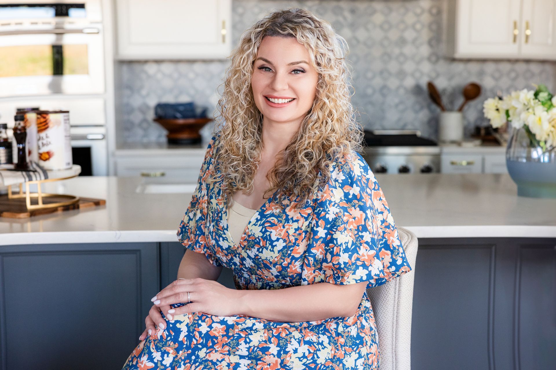 A woman is sitting in a chair in a kitchen.