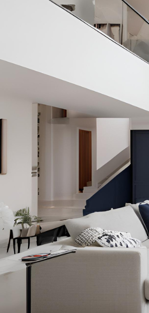 A living room with a couch and stairs in the background