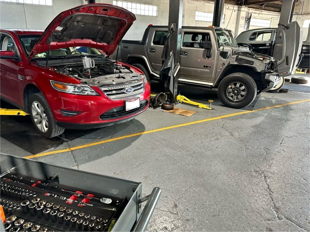 Black Buick SUV on a lift in a garage, with chrome accents and red wheels.