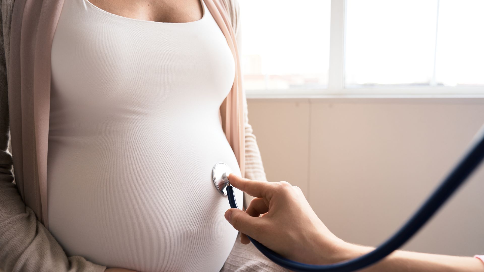 Bilde av en gravid mage og noen som lytter.