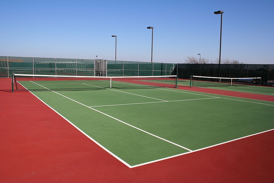 a green and red tennis court with white lines
