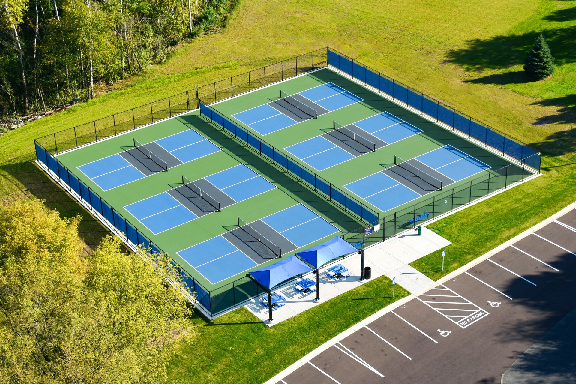 an aerial view of a person playing tennis on a court