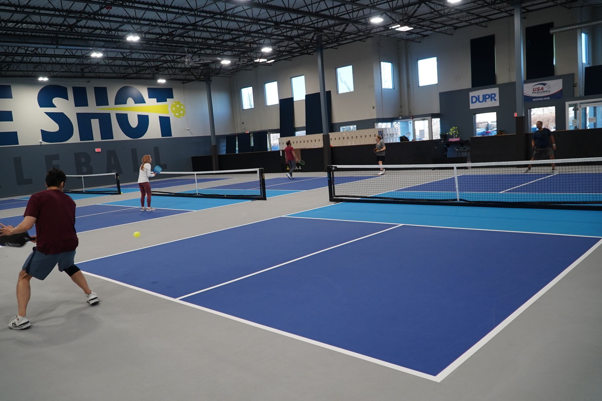 two women are playing tennis on a court with a handicap sign in the background