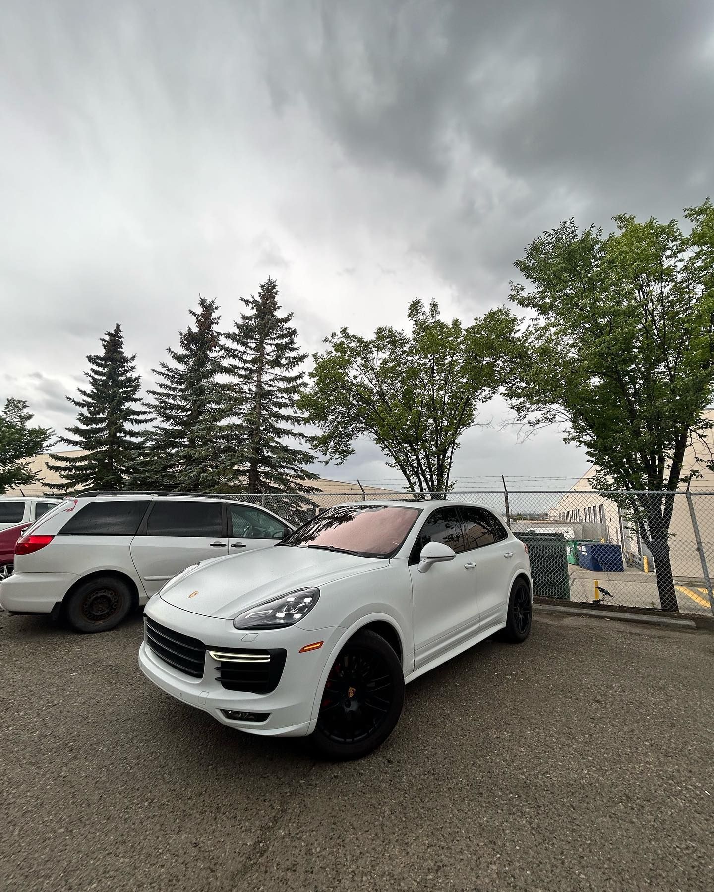 White Porsche SUV Parked on Gravel, With Other Cars | Economy Auto Repair