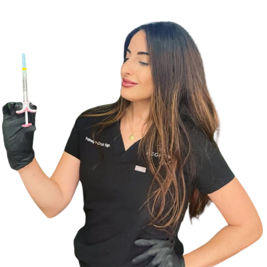Woman in scrubs holding syringe, looking towards it, black gloves.