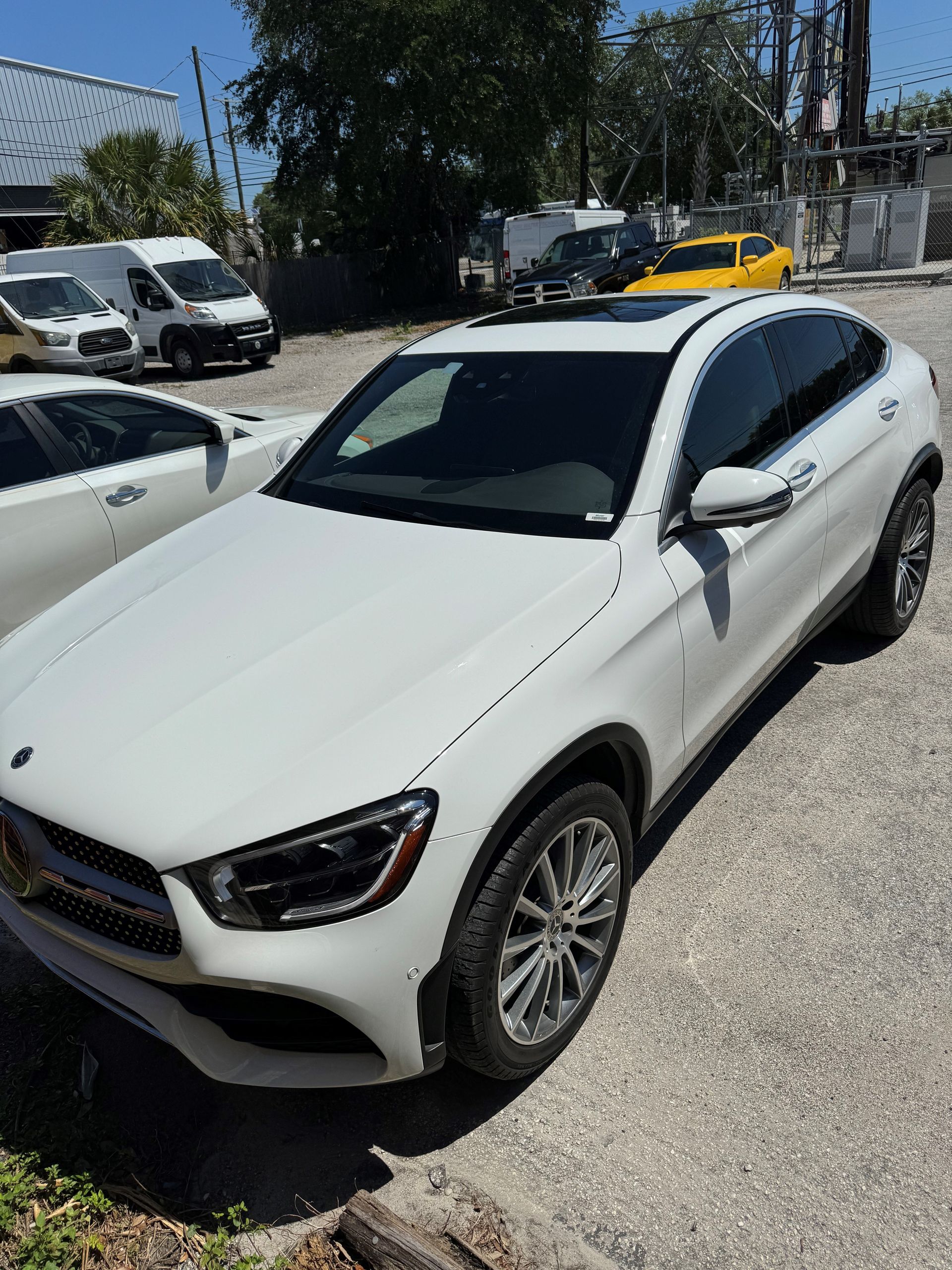 A white mercedes benz glc 300 is parked in a parking lot.