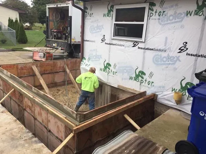 A man is working on a foundation of a house.
