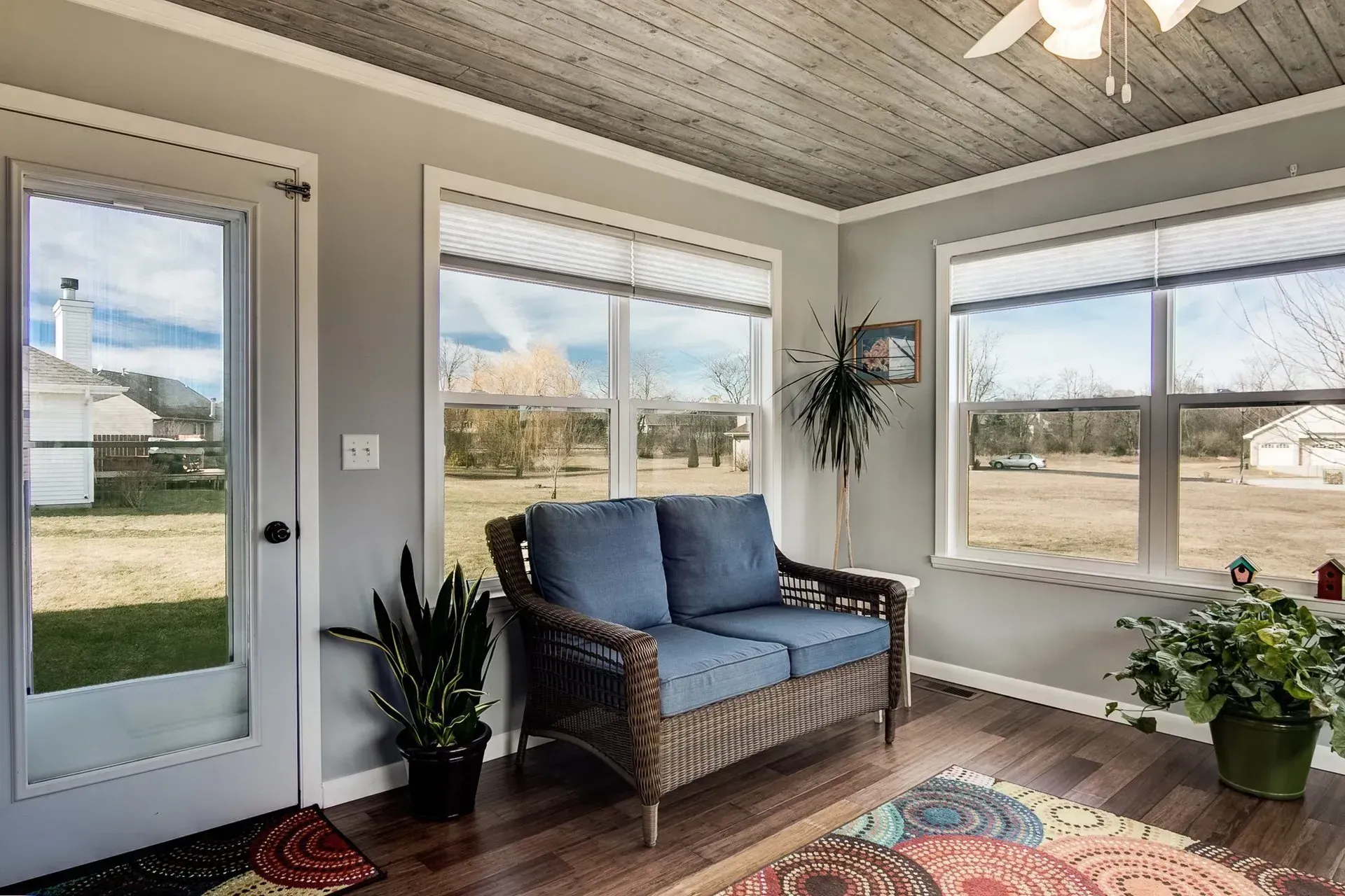 A living room with a couch and a lot of windows.