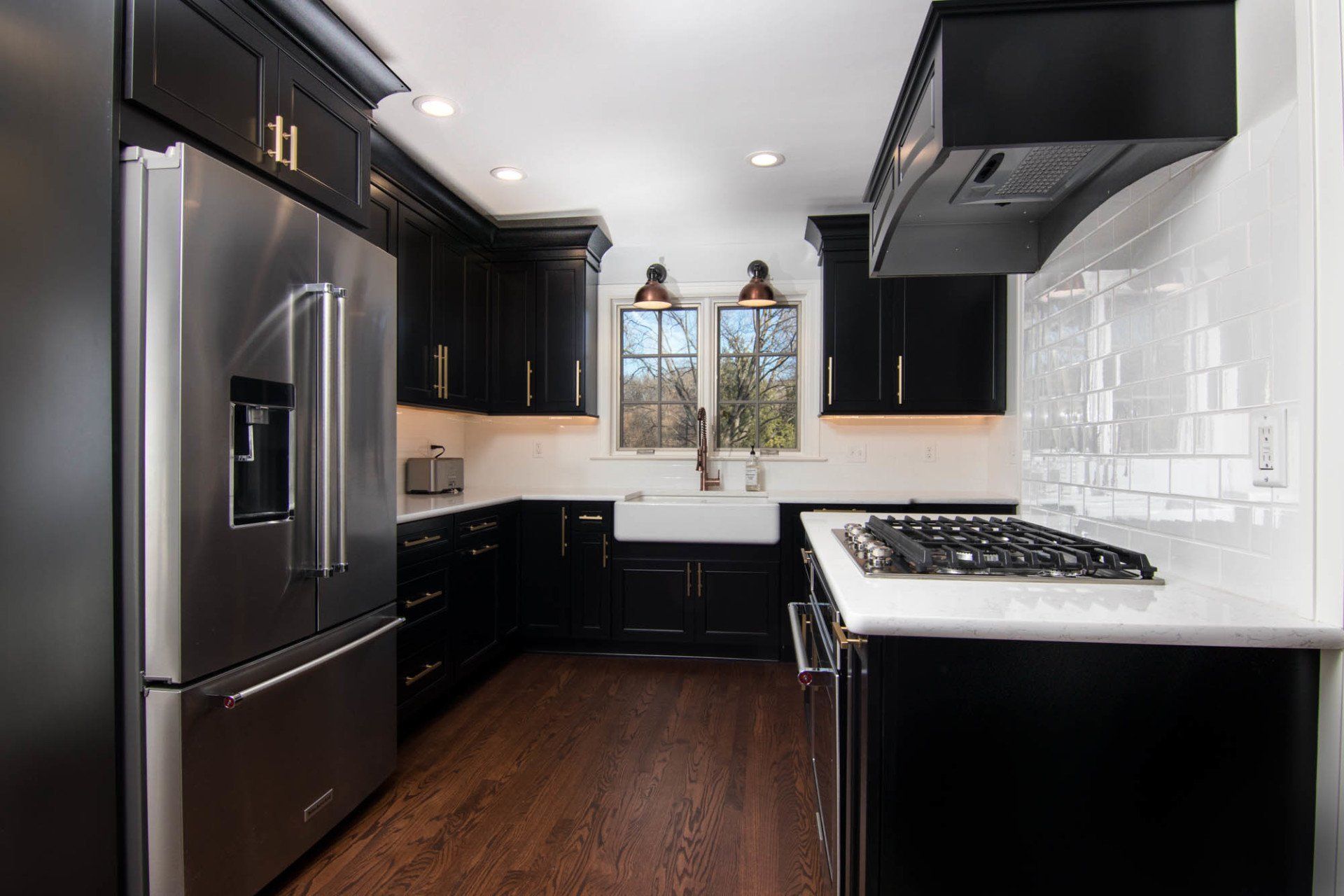 A kitchen with black cabinets and stainless steel appliances.