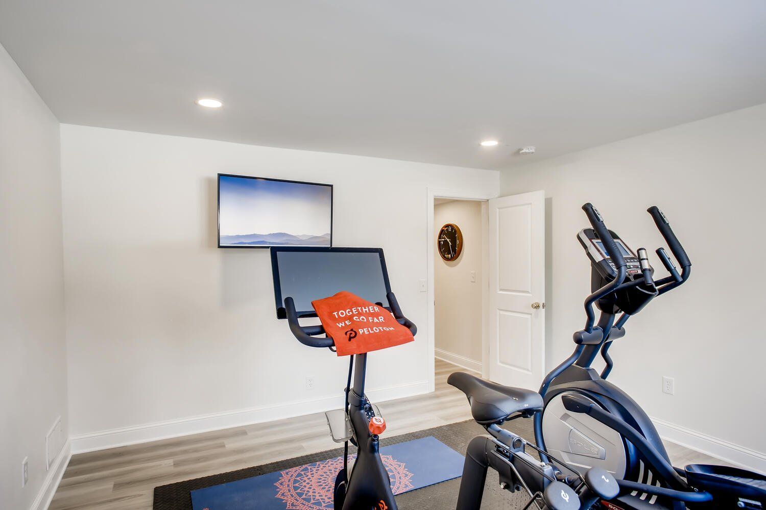 A home gym with an exercise bike , treadmill , and television.