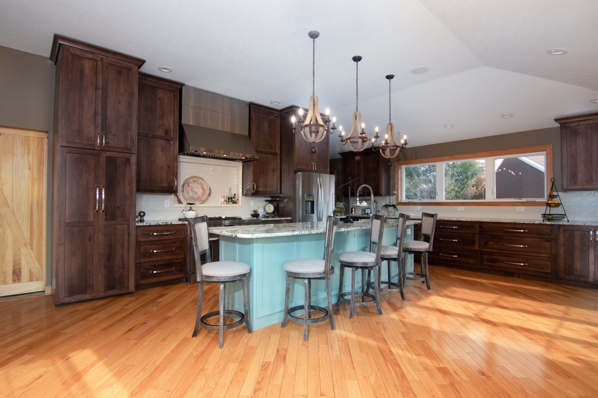 A large kitchen with wooden cabinets and a large island in the middle.