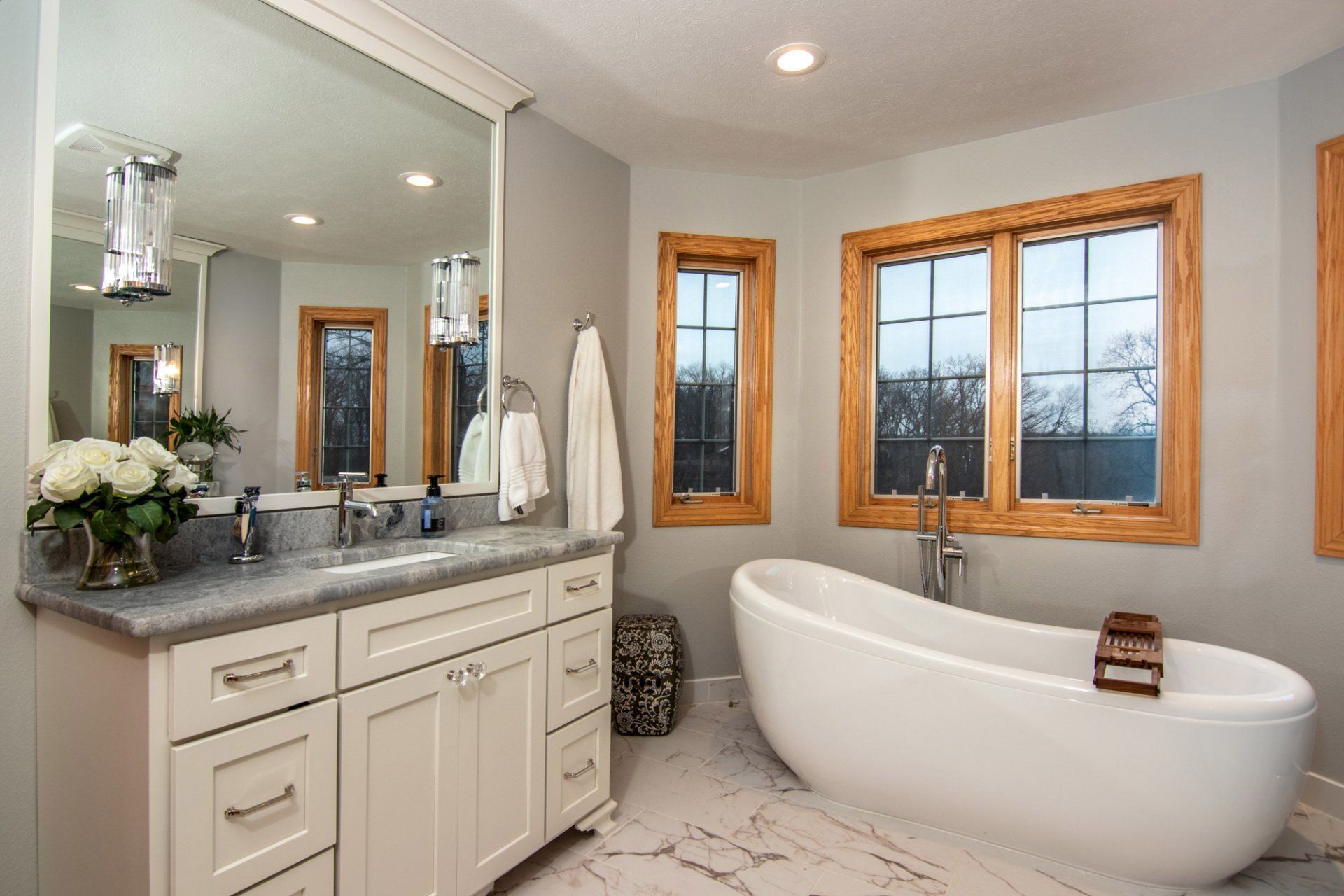 A bathroom with a tub , sink and mirror.