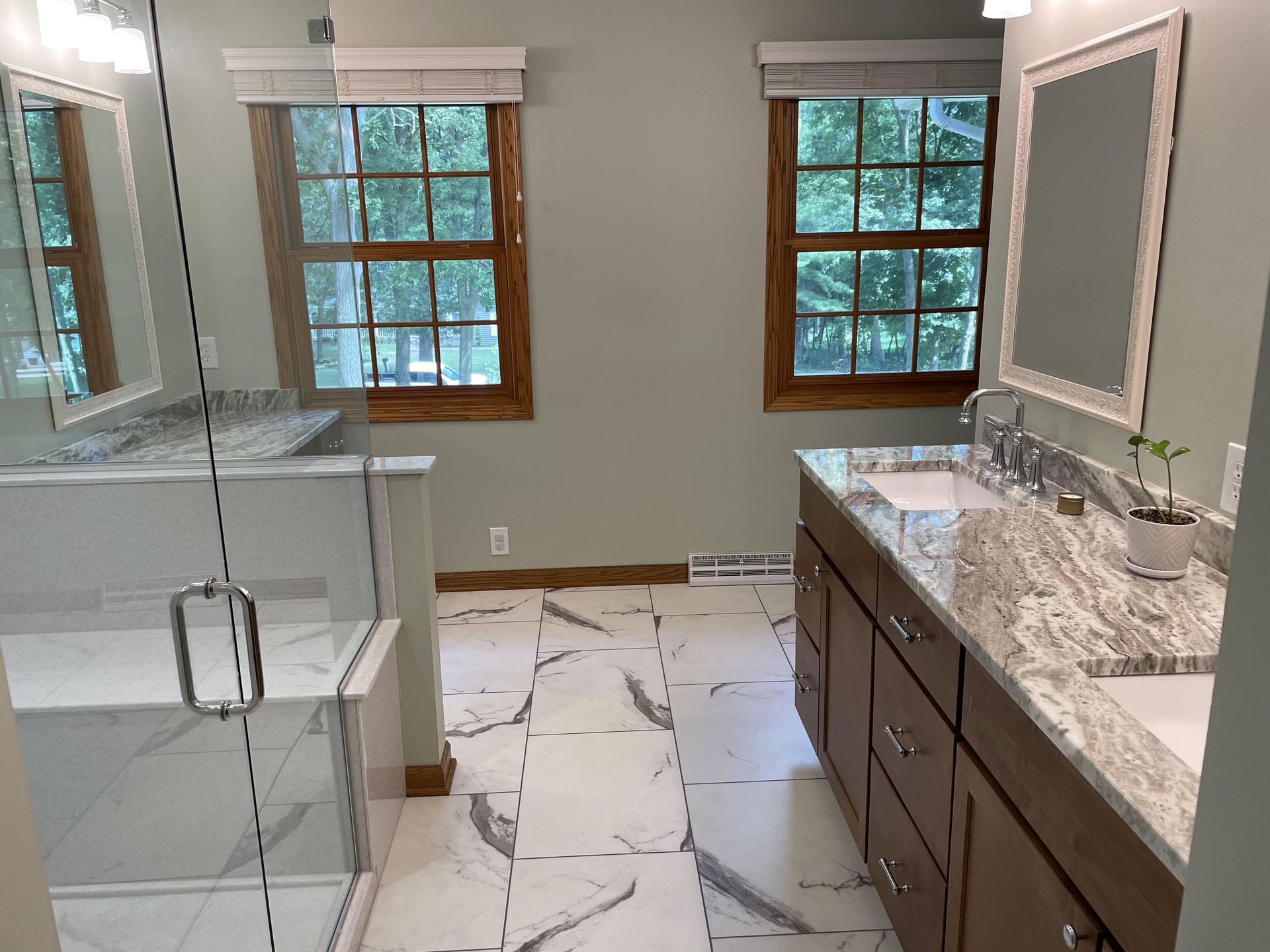 A bathroom with two sinks and a walk in shower.