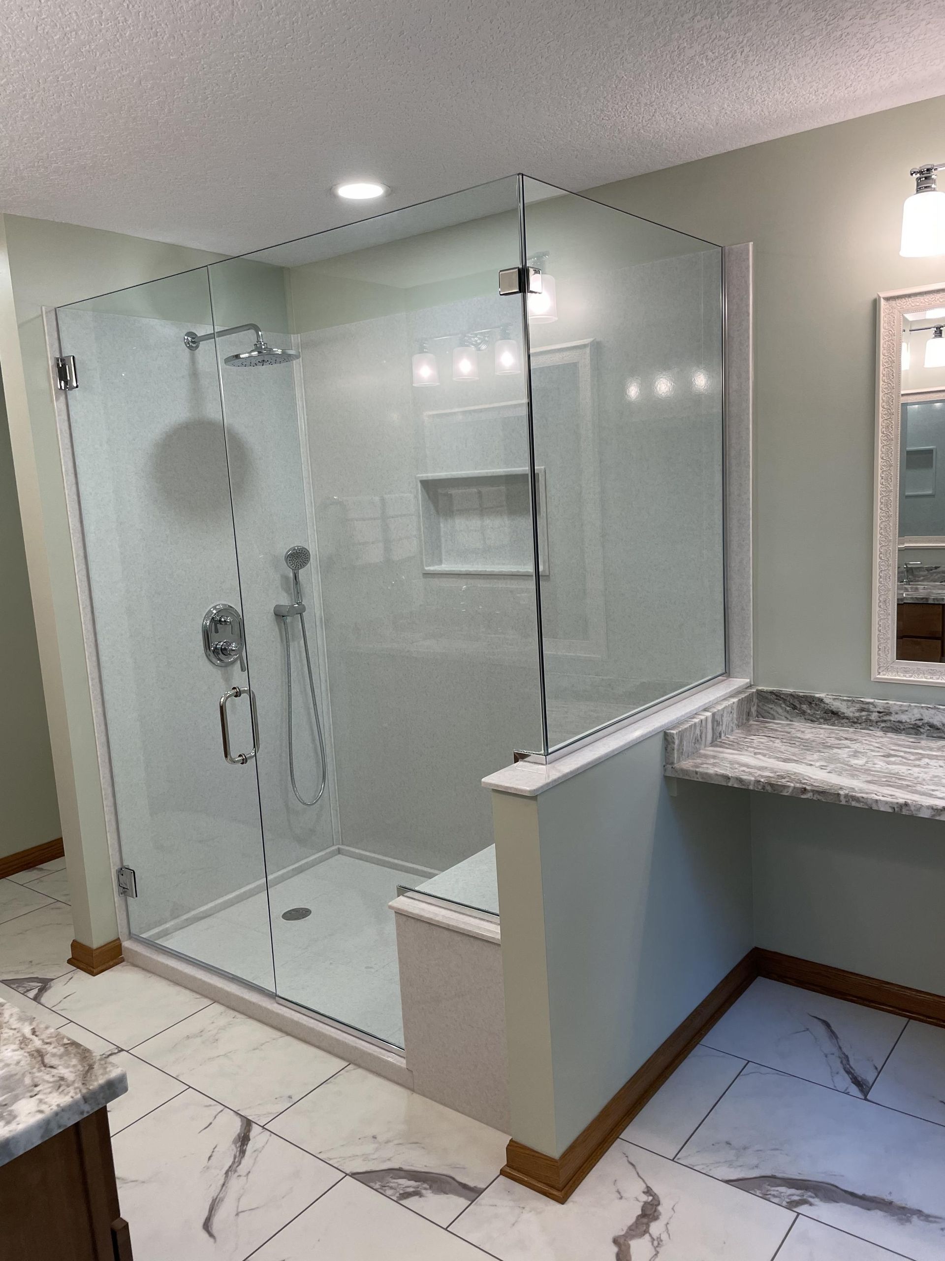 A bathroom with a walk in shower and a sink.