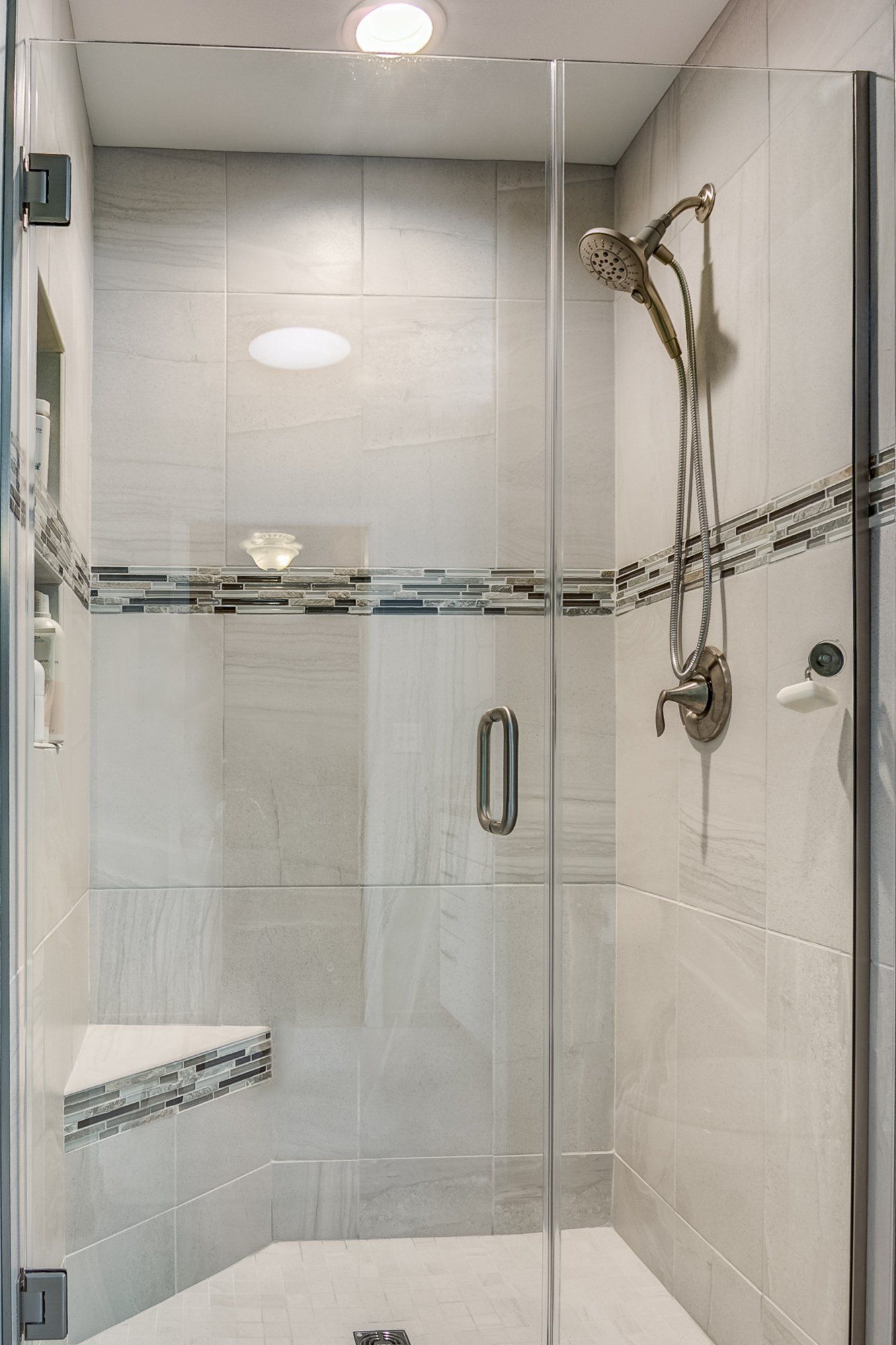 A shower with a glass door and a shower head.
