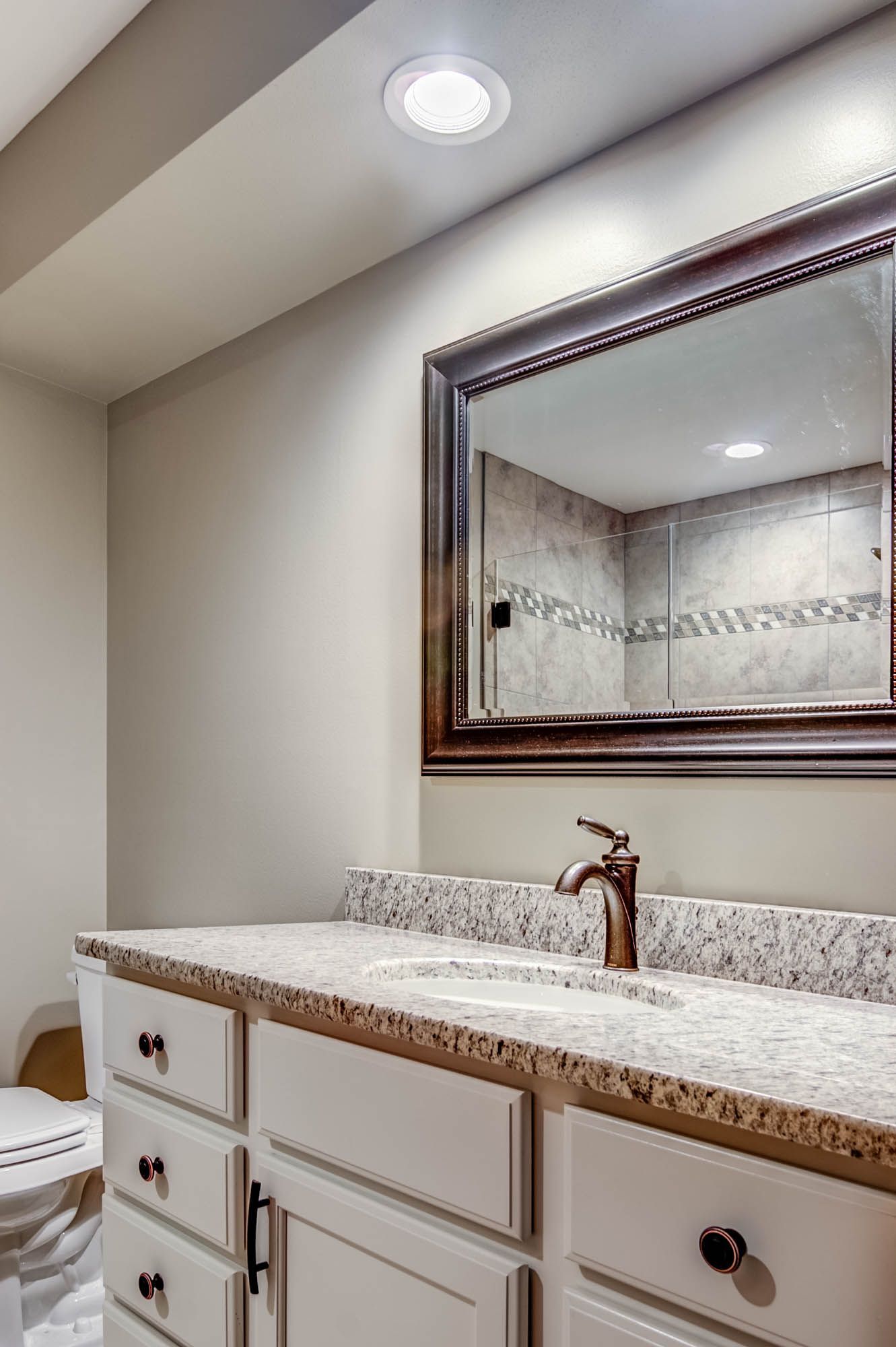 A bathroom with a sink , toilet and mirror.