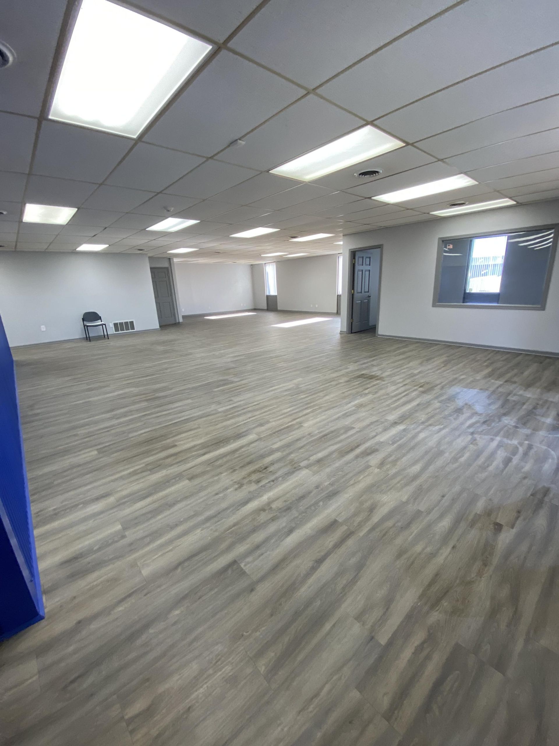 A large empty room with wooden floors and white walls.