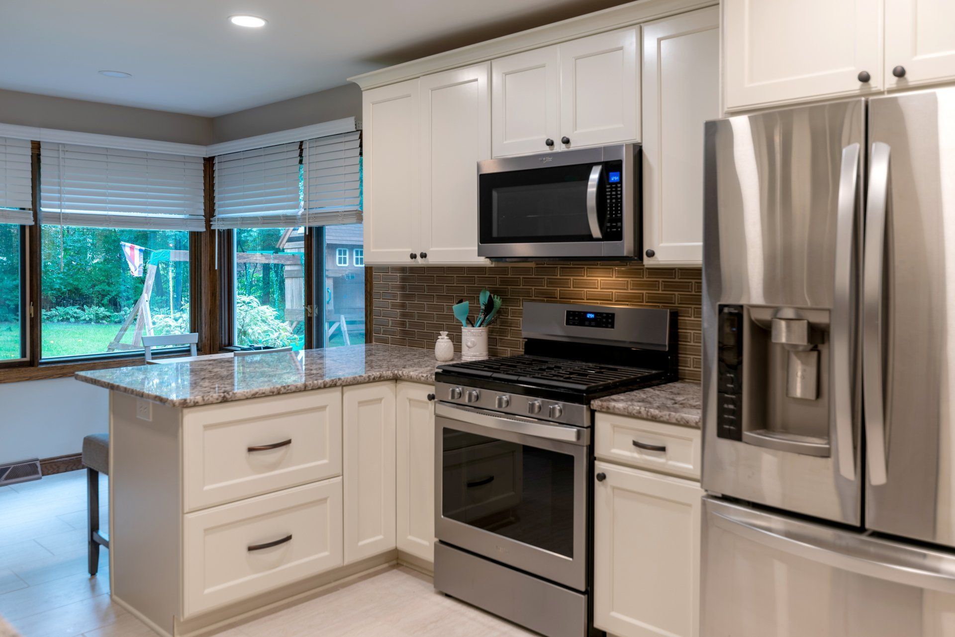 A kitchen with stainless steel appliances and white cabinets.