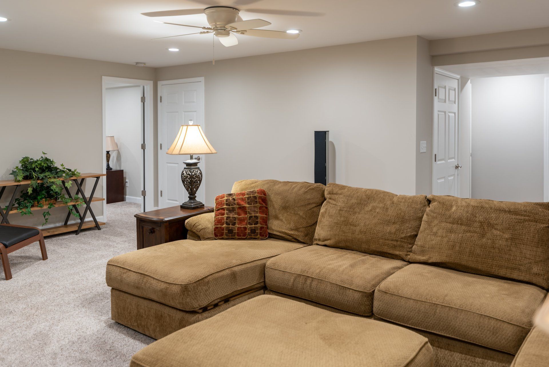 A living room with a couch and a ceiling fan.