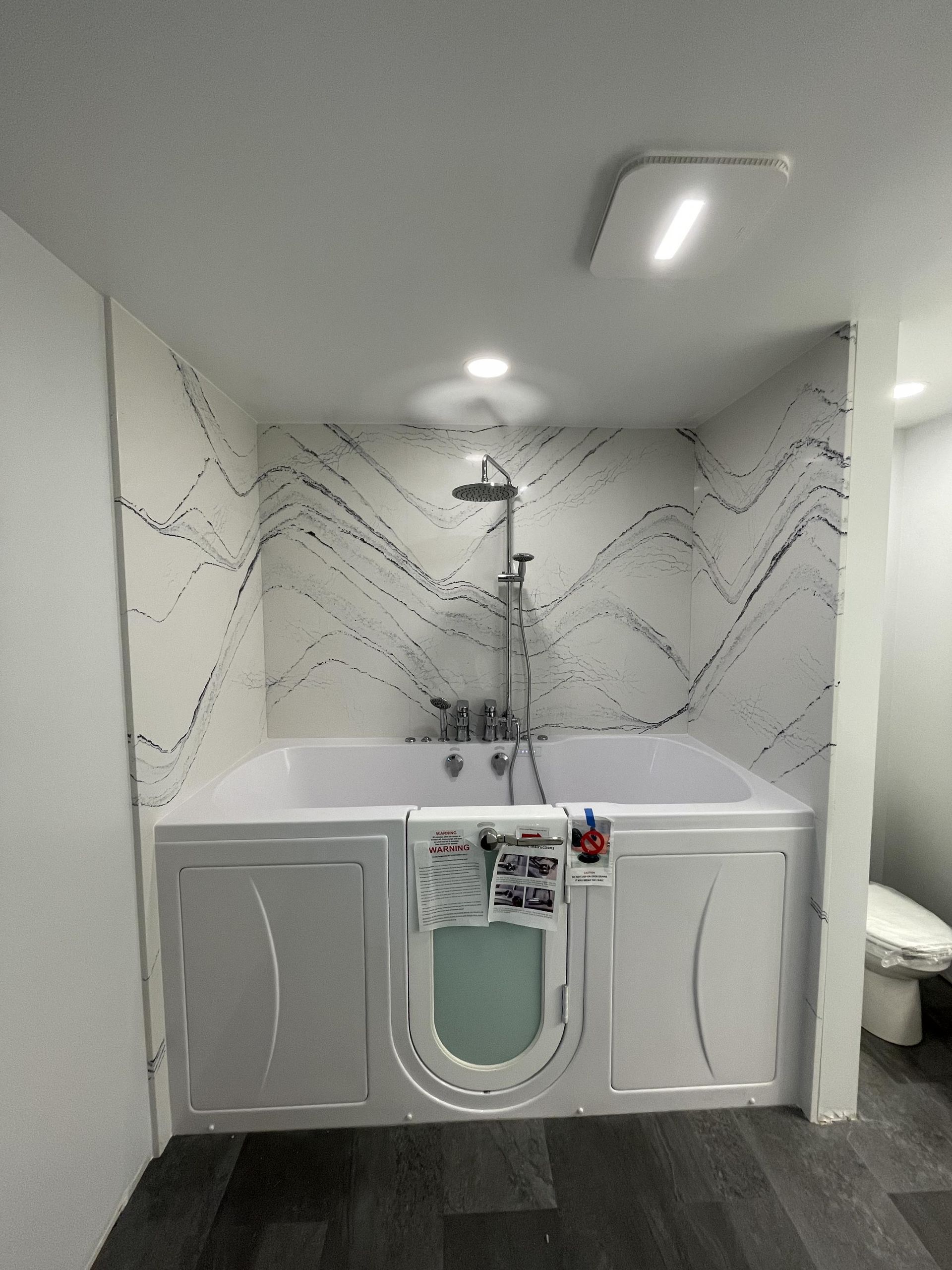 A bathroom with a walk in tub and a toilet.